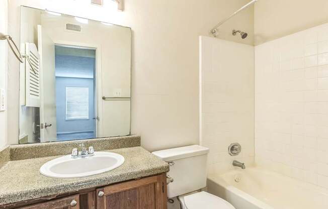 A bathroom with a sink, toilet, and bathtub.
