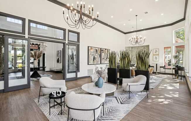 A modern living room with a white sofa set and a chandelier.