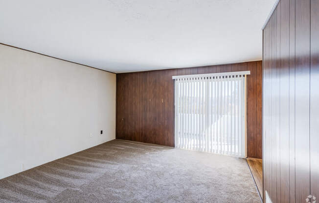 A room with a carpeted floor and a wooden door.