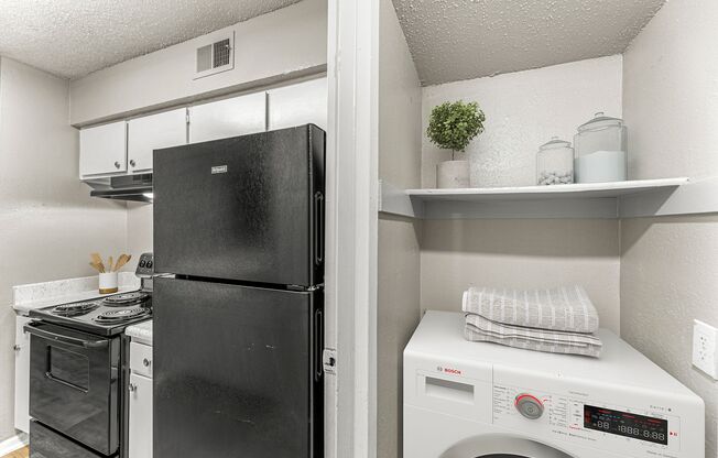 a laundry room with a refrigerator and a washing machine