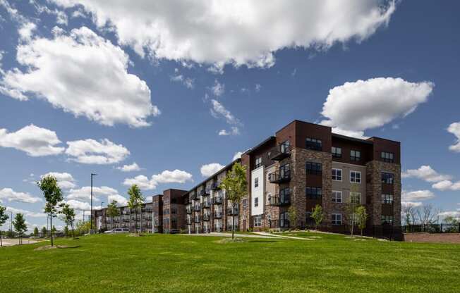 an apartment building on a hill with a grass field