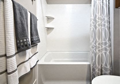 a bathroom with a shower and a toilet and towels