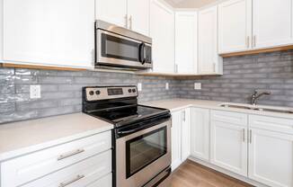 a kitchen with white cabinets and stainless steel appliances