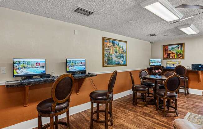 A room with a long table and chairs, a TV, and a painting on the wall.