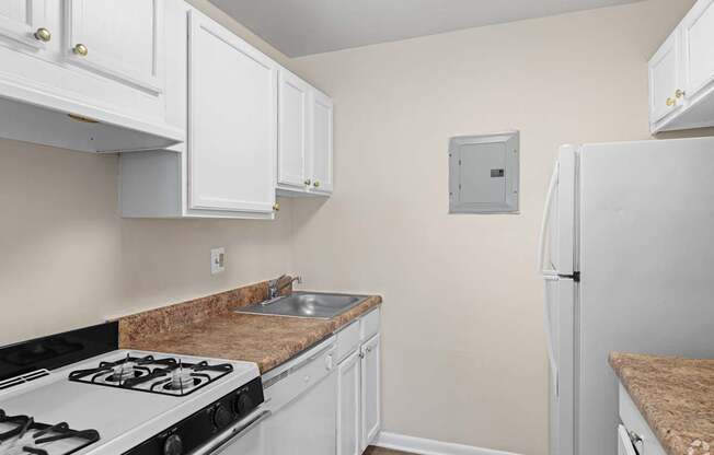 A kitchen with white cabinets and a stove top oven.