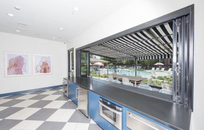 a kitchen with a counter and a window overlooking a pool