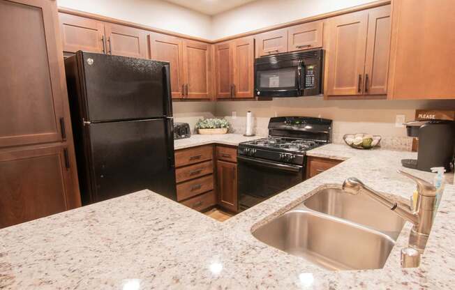 a kitchen with black appliances and granite counter tops