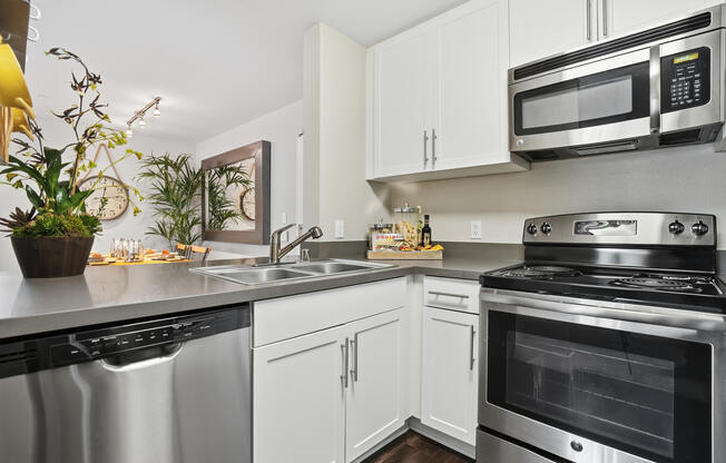 A modern kitchen with stainless steel appliances and white cabinets.