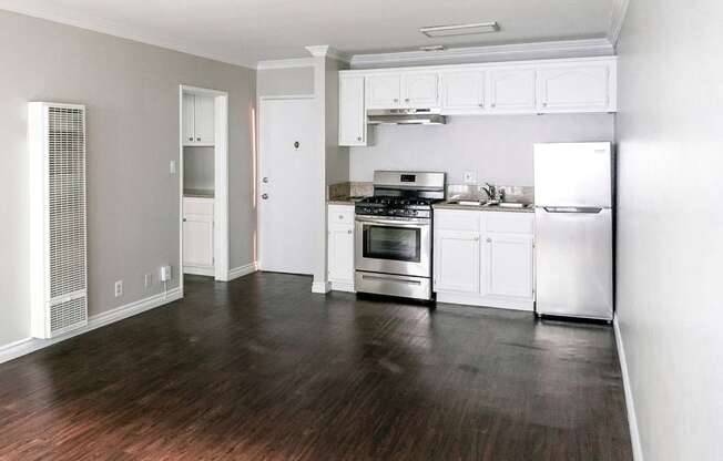 a kitchen with white cabinets and a stove and a refrigerator