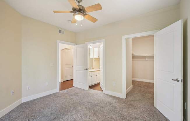 A room with a ceiling fan and carpeted floor.