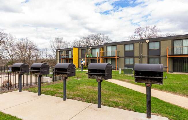 A row of black mailboxes in front of a building.