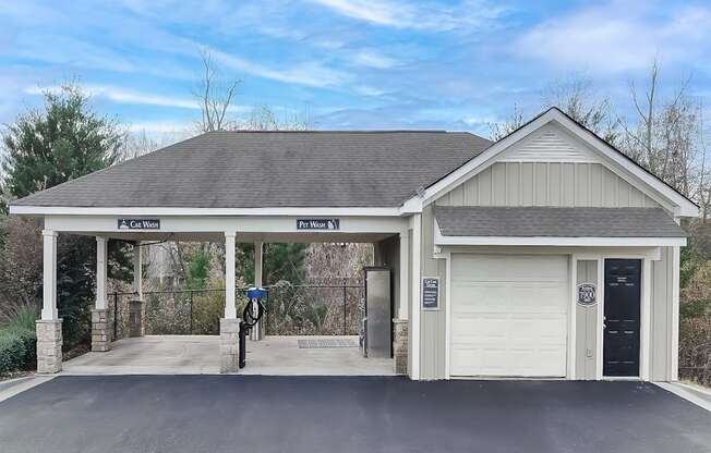 the front of a garage with a driveway and a white door