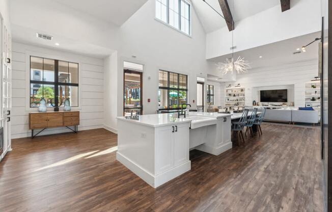 a white kitchen with a large island and a dining room table