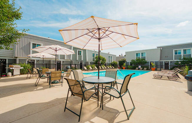 our apartments have a pool and patio with chairs and umbrellas