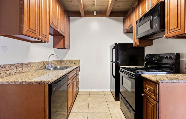 a kitchen with wooden cabinets and black appliances