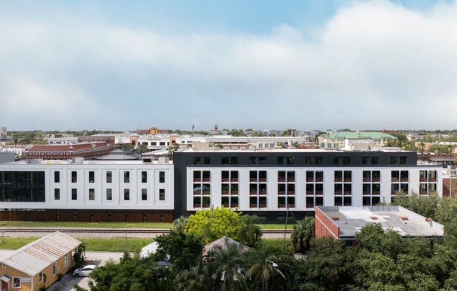 an aerial view of a large white building with a city in the background