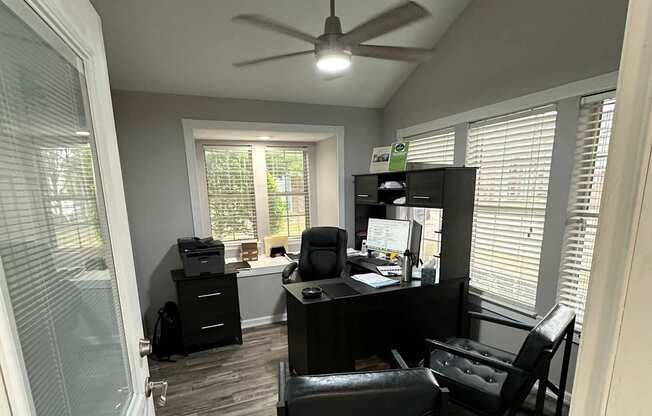 A modern bathroom with a glass shower and a ceiling fan.