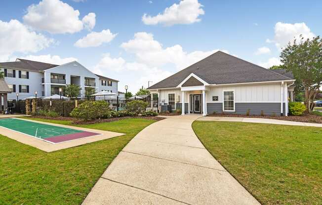 a house with a basketball court and a sidewalk at Avalon Apartment Homes, Starkville