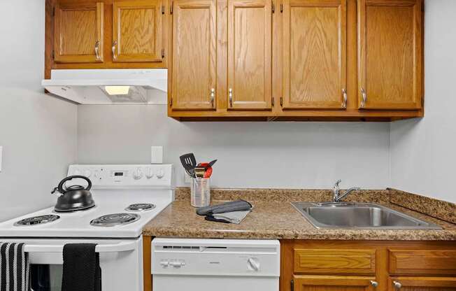 A kitchen with wooden cabinets and a granite counter top.