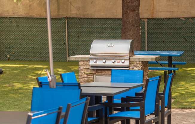 a patio with tables and chairs and an outdoor grill