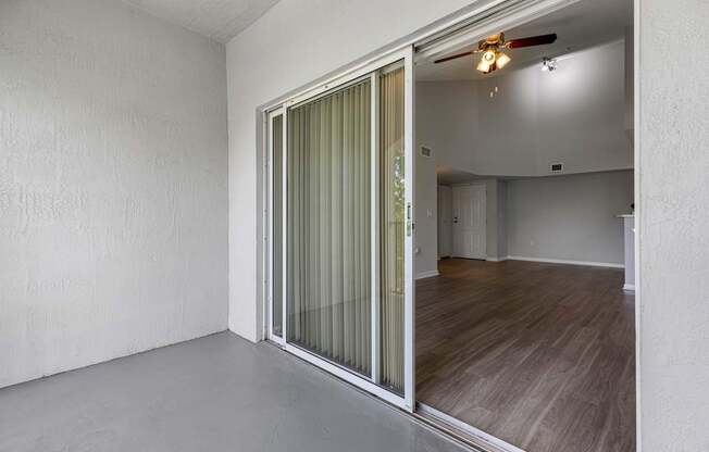 A room with a sliding door and a fan on the ceiling.