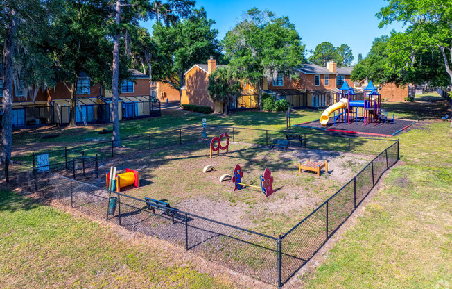 a playground at a park in a fenced in area