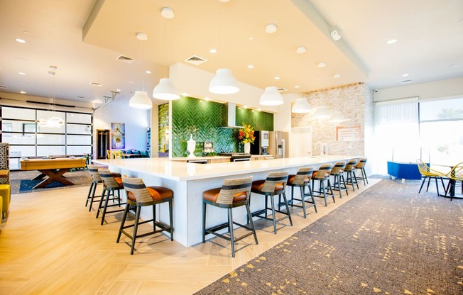 a long bar with chairs and a table in a lobby