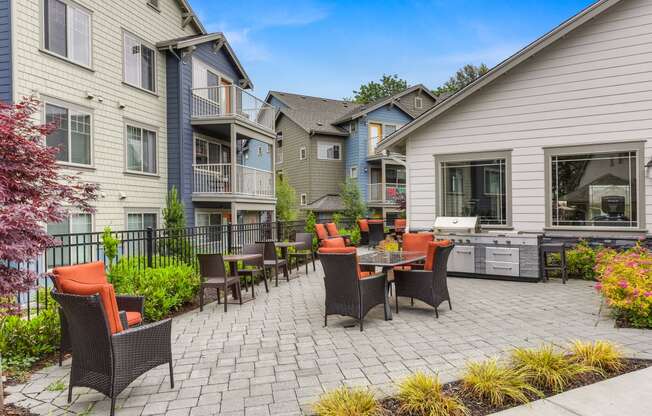 Outdoor Seating Area with Grill, Orange Chairs, Tile Inspired Floor, Blue Apartment Exterior