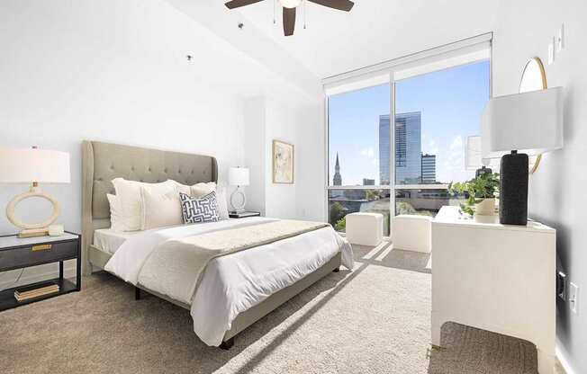 A bedroom with a large bed and a view of the city.