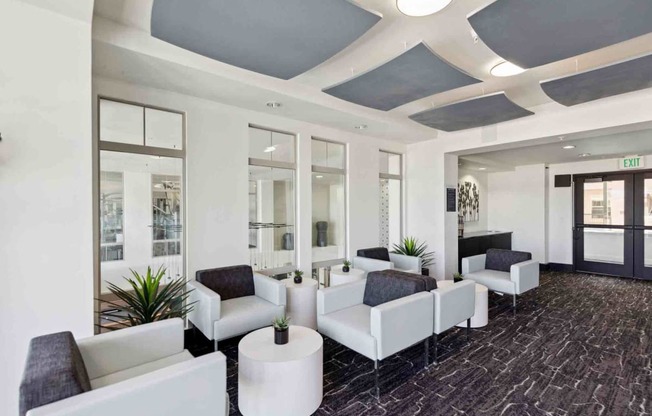 a lobby of a building with white couches and chairs