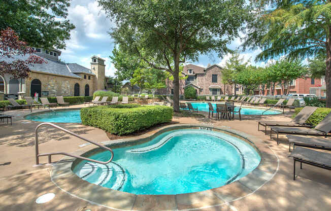 A large outdoor swimming pool surrounded by lounge chairs and trees.
