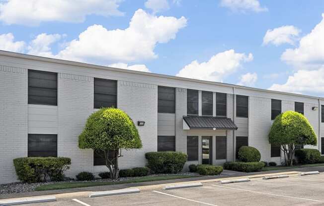 an office building with a parking lot and trees at Brookside Apartments, Hewitt, TX