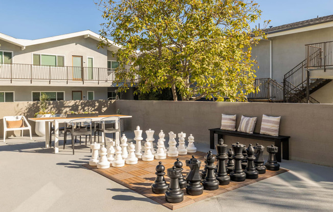 a large chess set on a table in front of a house