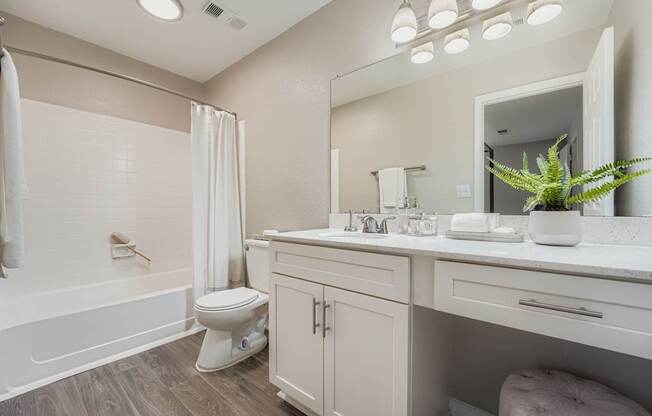 A white bathroom with a toilet, sink, and bathtub.