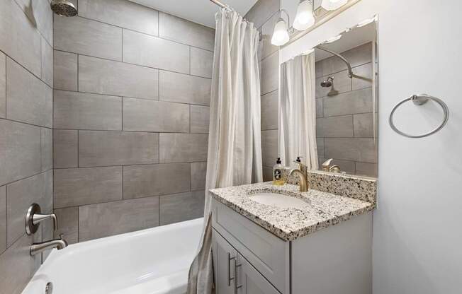 a bathroom with a sink and a shower and a tub