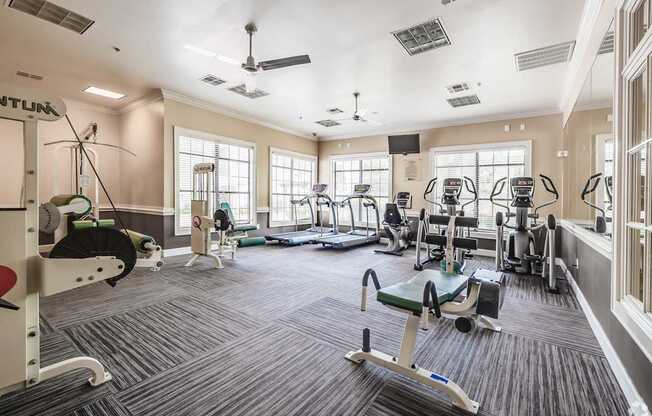 A spacious gym with a variety of equipment including treadmills, exercise bikes, and weight machines.