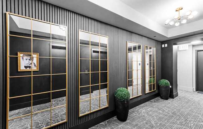 A hallway with black walls and gold framed windows.