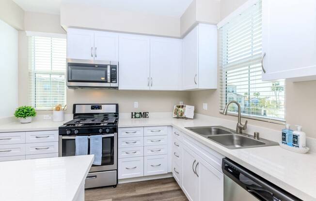 a kitchen with white cabinets and stainless steel appliances