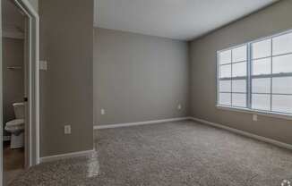 A room with a carpeted floor and a window with blinds.at The Residences at Akita Lane, Ohio