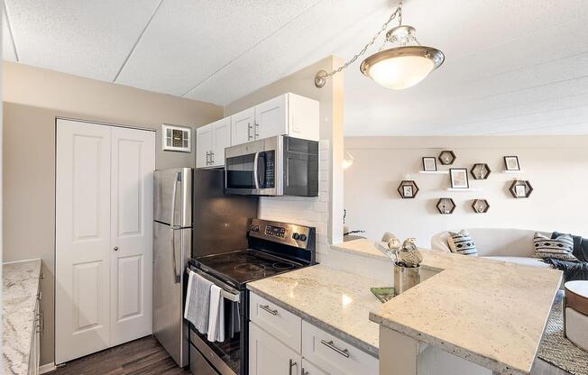 a kitchen with stainless steel appliances and a counter top at Troy Place Apartments - Troy, MI, Troy, 48084
