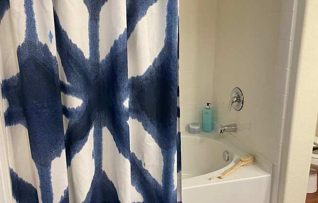 A blue and white bathroom rug with a pattern of trees.