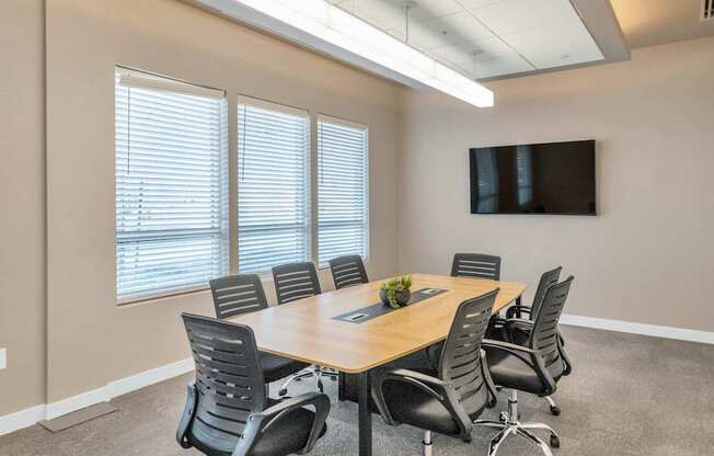 A conference room with a long table and chairs.