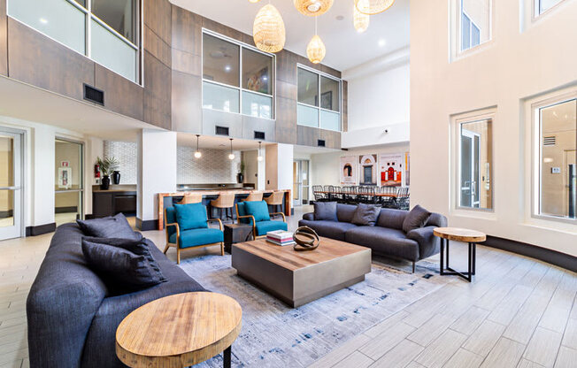 a living room with couches and chairs and a kitchen