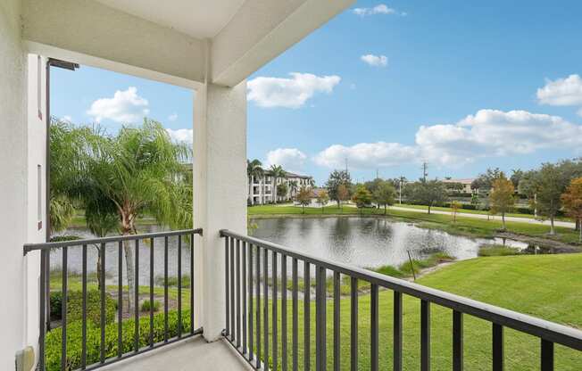 A balcony overlooks a pond and a park.