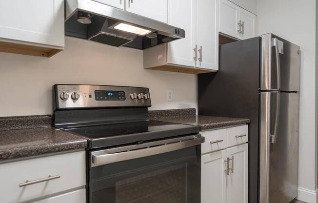 a kitchen with stainless steel appliances and white cabinets