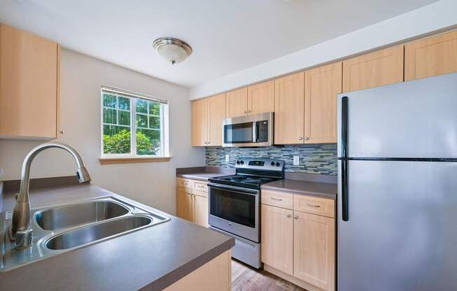 York kitchen with stainless steel appliances and a window at Abbey Rowe Apartments in Olympia, WA