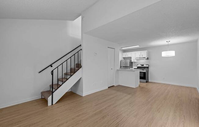 A kitchen with a staircase leading to the upper floor.