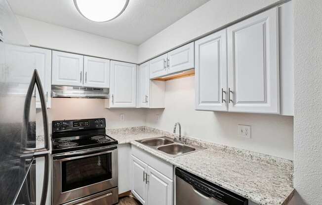 A kitchen with white cabinets and a granite countertop. at Glen at Lakewood, Lakewood, 80228