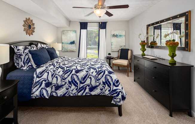 A bedroom with a large bed and a ceiling fan.