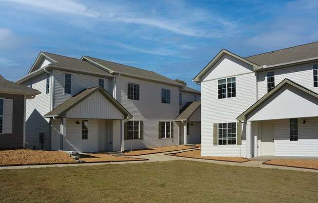 a row of newly built houses with green grass and neat sidewalks at The Sanctuary at Indian Creek